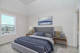 A bedroom with a large bed and a painting on the wall.