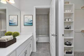 A bathroom with a white countertop and a white door.