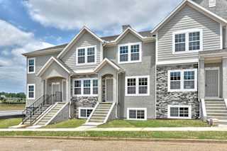 a large house with stone and gray siding