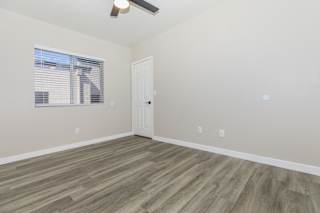 A room with a white door and a window with blinds.