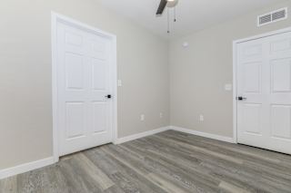 A room with a white door and a grey floor.
