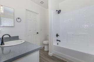 A bathroom with a sink, toilet, and shower.