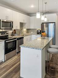 A kitchen with a granite countertop and stainless steel appliances.