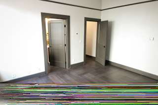 A hallway with two doors and a striped rug on the floor.