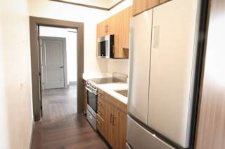 A kitchen with a refrigerator, oven, and microwave.