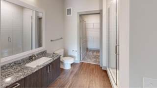 A bathroom with a toilet, sink, and a walk-in shower.