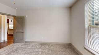 A room with a rug on the floor and a door on the left.