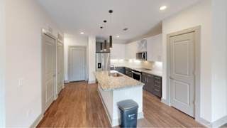 A kitchen with a countertop and a trash can.