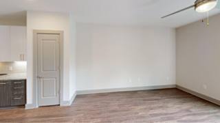 A 3D floor plan of a small apartment with a living room, kitchen, and bathroom.