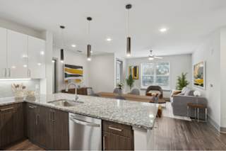 A modern kitchen with a granite countertop and stainless steel appliances.