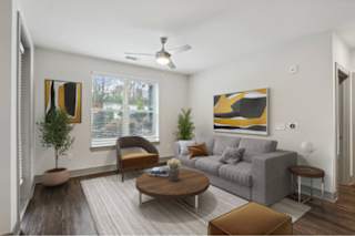 A living room with a grey couch, a brown coffee table, and a ceiling fan.