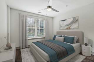 A bedroom with a bed, nightstand, and window.
