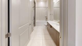A white bathroom with a toilet, sink, and mirror.