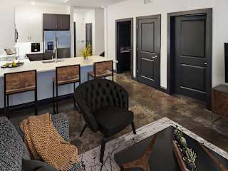 A modern living room with a black chair and a grey couch.