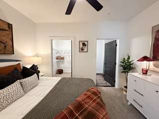 Spacious bedroom with walk-in closet and en suite bathroom at The Wren Apartments, Lawrenceville, Georgia
