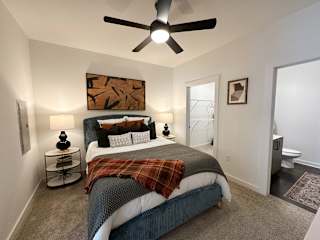 Modern bedroom with ceiling fan and ensuite bathroom at The Wren Apartments, Lawrenceville, GA 30043