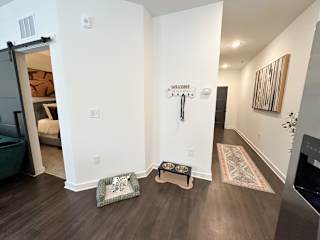 Entryway with pet station and barn door bedroom at The Wren Apartments, Lawrenceville