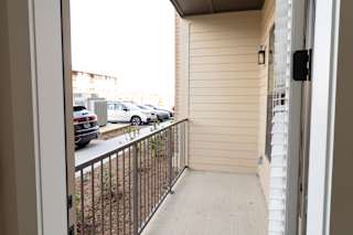 A balcony with a metal railing and a view of a parking lot.at District at Riverside Apartments, Chattanooga