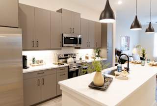 A modern kitchen with a white countertop and beige cabinets.at District at Riverside Apartments, Chattanooga, TN 37406