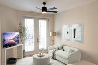 A living room with a television, a couch, and a fan.at Riverside Apartments, Chattanooga, TN