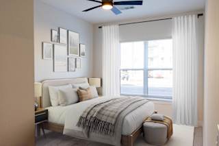 A bedroom with a large bed and a window with white curtains.at Riverside Apartments, Chattanooga, Tennessee