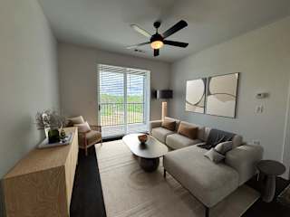 Living room with sectional sofa and ceiling fan at The Wren Apartments, Lawrenceville