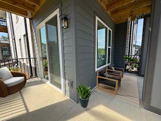 Covered patio with wood ceiling and modern seating at The Wren Apartments, Georgia
