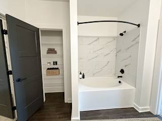 Bathroom with walk-in closet and tub shower combo at The Wren Apartments, Georgia, 30043