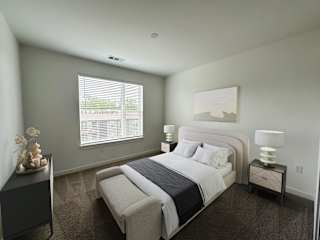 Bright bedroom with upholstered headboard and side tables at The Wren Apartments, Lawrenceville, GA 30043