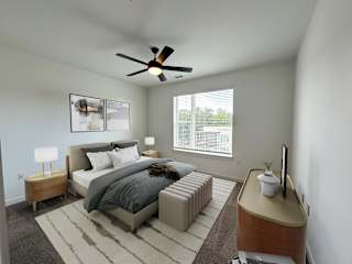 Bedroom with upholstered bed and ceiling fan at The Wren Apartments, Lawrenceville, 30043