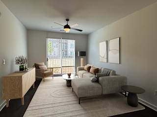 A living room with a grey couch, a wooden cabinet, a chair, a table, and a ceiling fan. at The Wren Apartments, Lawrenceville , GA