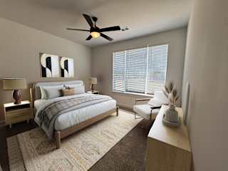 A bedroom with a bed, chair, and a fan. at The Wren Apartments, Lawrenceville , GA, 30043