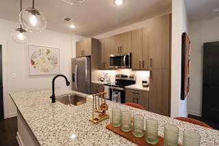 Kitchen with granite island and modern black faucet at The Wren Apartments, Georgia