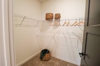 Walk-in closet with wire shelving and woven baskets at The Wren Apartments, Lawrenceville, 30043