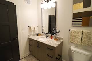 Bathroom vanity with granite countertop and decorative accents at The Wren Apartments, Lawrenceville