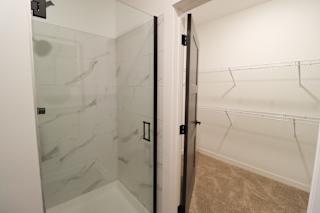 Walk-in closet with glass shower enclosure at The Wren Apartments, Lawrenceville, GA