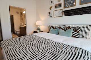 Bedroom with patterned bedding and ensuite bathroom at The Wren Apartments, Georgia, 30043