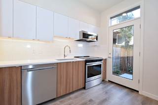 A kitchen with white cabinets and a stainless steel dishwasher.