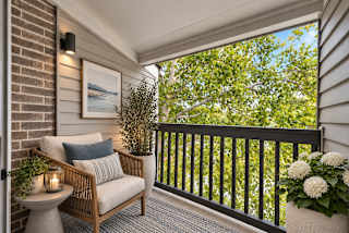 A balcony with a chair, table, and plants.