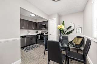 A kitchen with a dining table and chairs.