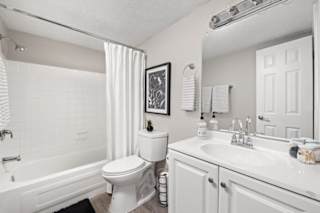 A white bathroom with a toilet, sink, and bathtub.