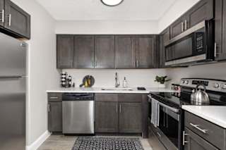 A kitchen with dark wood cabinets and stainless steel appliances.