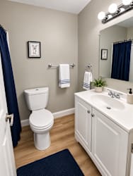A white toilet sits next to a white sink in a bathroom.