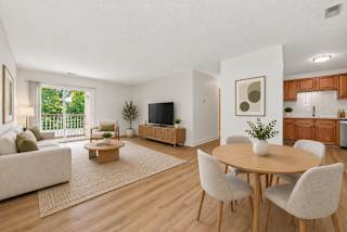A living room with a couch, chairs, and a television.