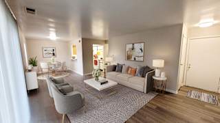 A modern living room with a grey sofa, a coffee table, and a grey armchair.