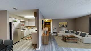 A modern kitchen with a refrigerator, sink, and dining table.