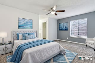 A bedroom with a large bed and a ceiling fan.