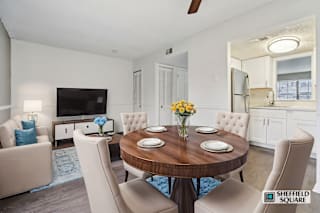A modern dining room with a wooden table and white chairs.
