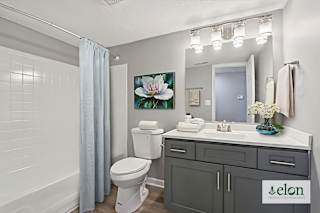 A bathroom with a toilet, sink, and a mirror.
