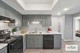 A modern kitchen with a stove top oven, sink, and cabinets.